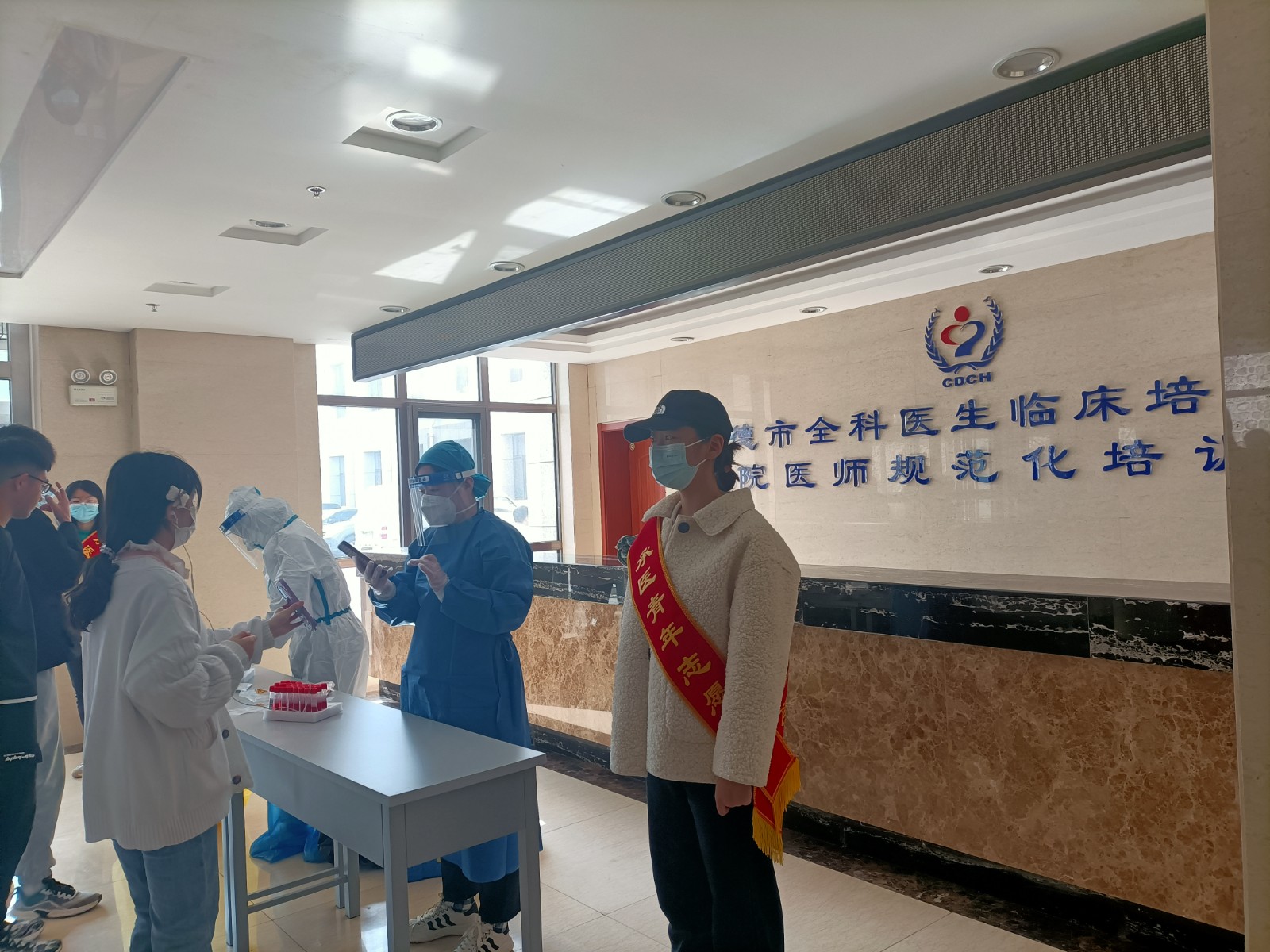 志愿者在承德市中心医院全科医生培训基地组织核酸排队